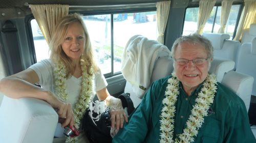 Nelly et Hubert dans leur bus portant le collier de fleurs.