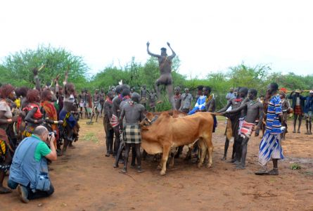 Le jeune homme saute les vaches encouragé par les femmes